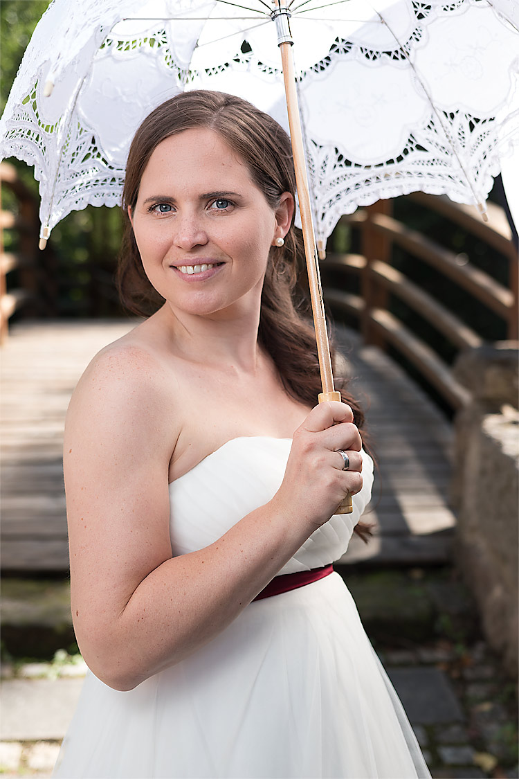 Braut mit dekorativem Sonnenschirm
